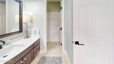 a kitchen with stainless steel appliances a sink dishwasher a stove a flat tv screen and a wooden cabinets