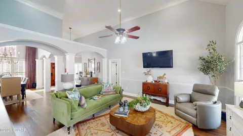 a living room with furniture a flat screen tv and a large window