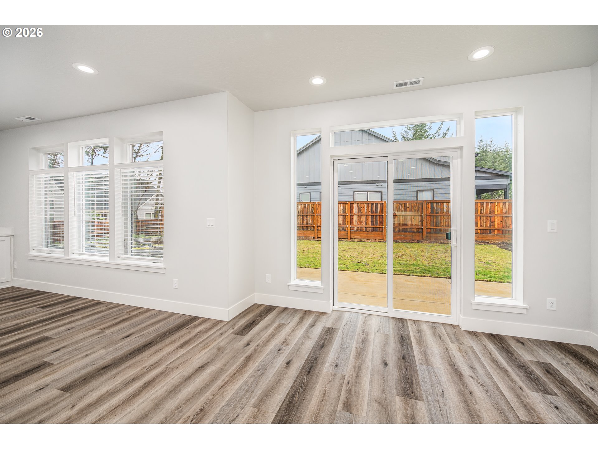24678 Perkins Road, Unit LOT 26 Veneta, OR 97487 - Photo 12 of 48 a view of an empty room with wooden floor and windows