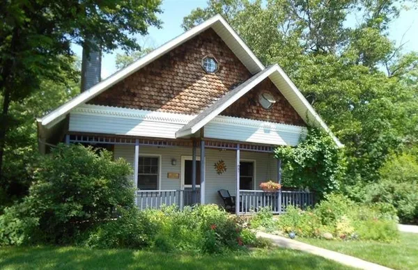 an aerial view of a house with a yard and a large tree