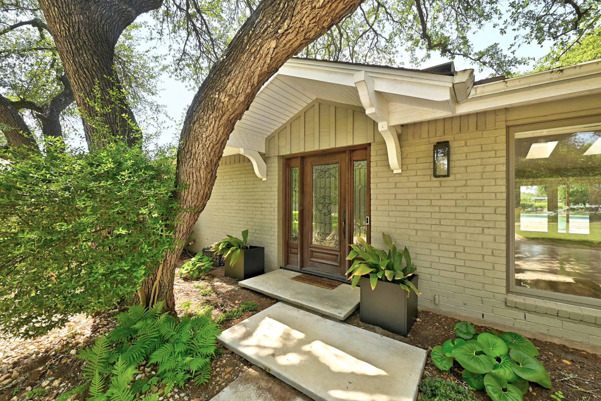 8608 Crest Ridge Circle Austin, TX 78750 - Photo 6 of 38 An inviting entry framed by mature trees, leading to a home with classic brick detailing.