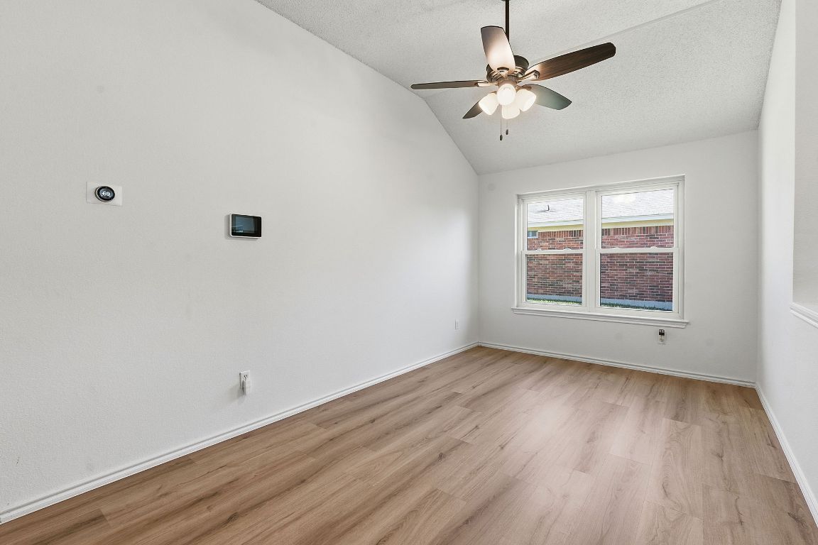 1203 Crossvine Way Pflugerville, TX 78660 - Photo 16 of 22 an empty room with wooden floor chandelier fan and windows