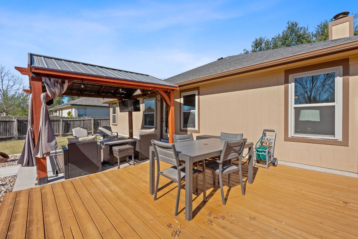 1203 Crossvine Way Pflugerville, TX 78660 - Photo 21 of 22 a view of a patio with table and chairs with wooden floor and fence