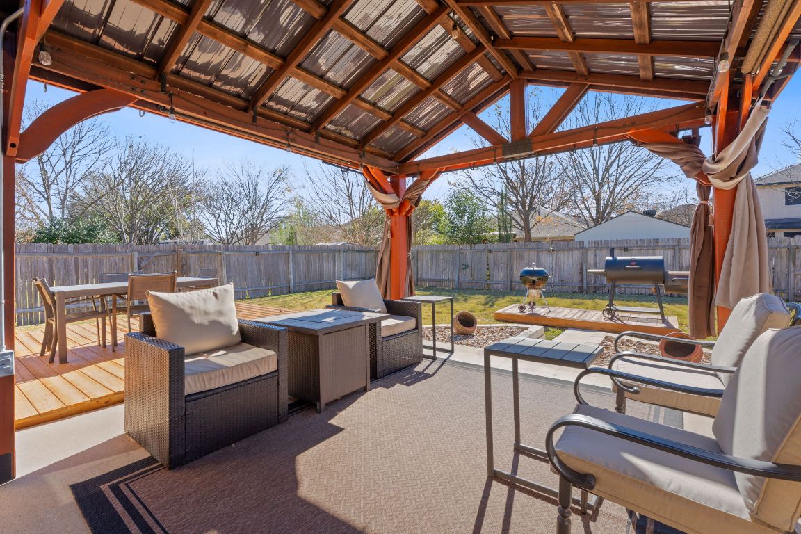 1203 Crossvine Way Pflugerville, TX 78660 - Photo 3 of 22 a view of a patio with a table chairs and a barbeque