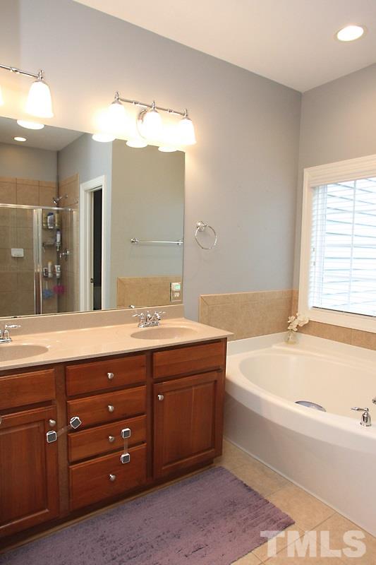 3520 Edgemont Drive Raleigh, NC 27612 - Photo 11 of 12 a spacious bathroom with a tub sink and mirror