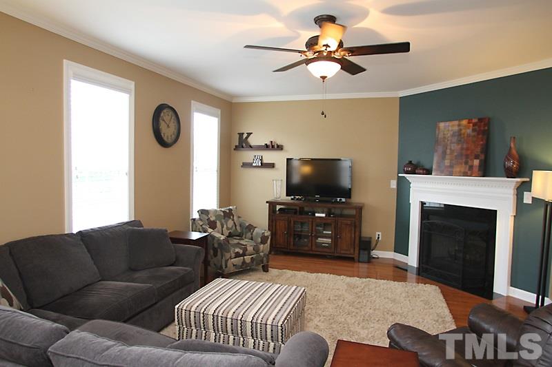 3520 Edgemont Drive Raleigh, NC 27612 - Photo 4 of 12 a living room with furniture a flat screen tv and a fireplace