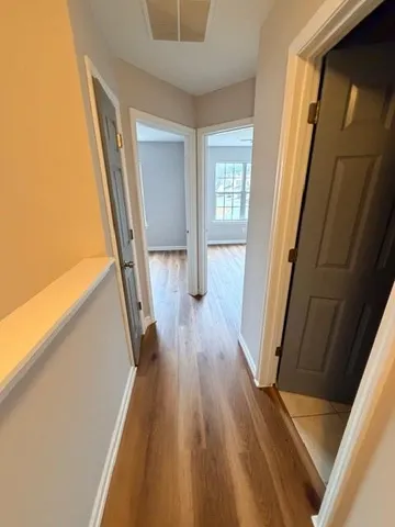 a view of a hallway with wooden floor and staircase
