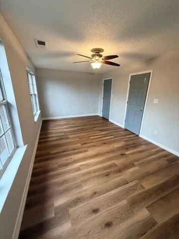 a view of a hallway with wooden floor and staircase