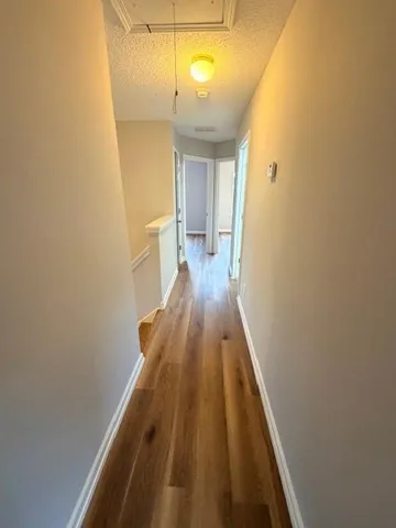 a view of a hallway with wooden floor