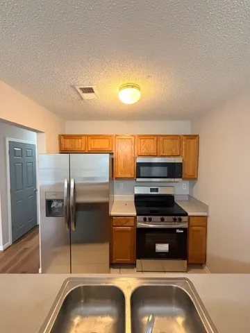 a kitchen with a sink and stainless steel appliances