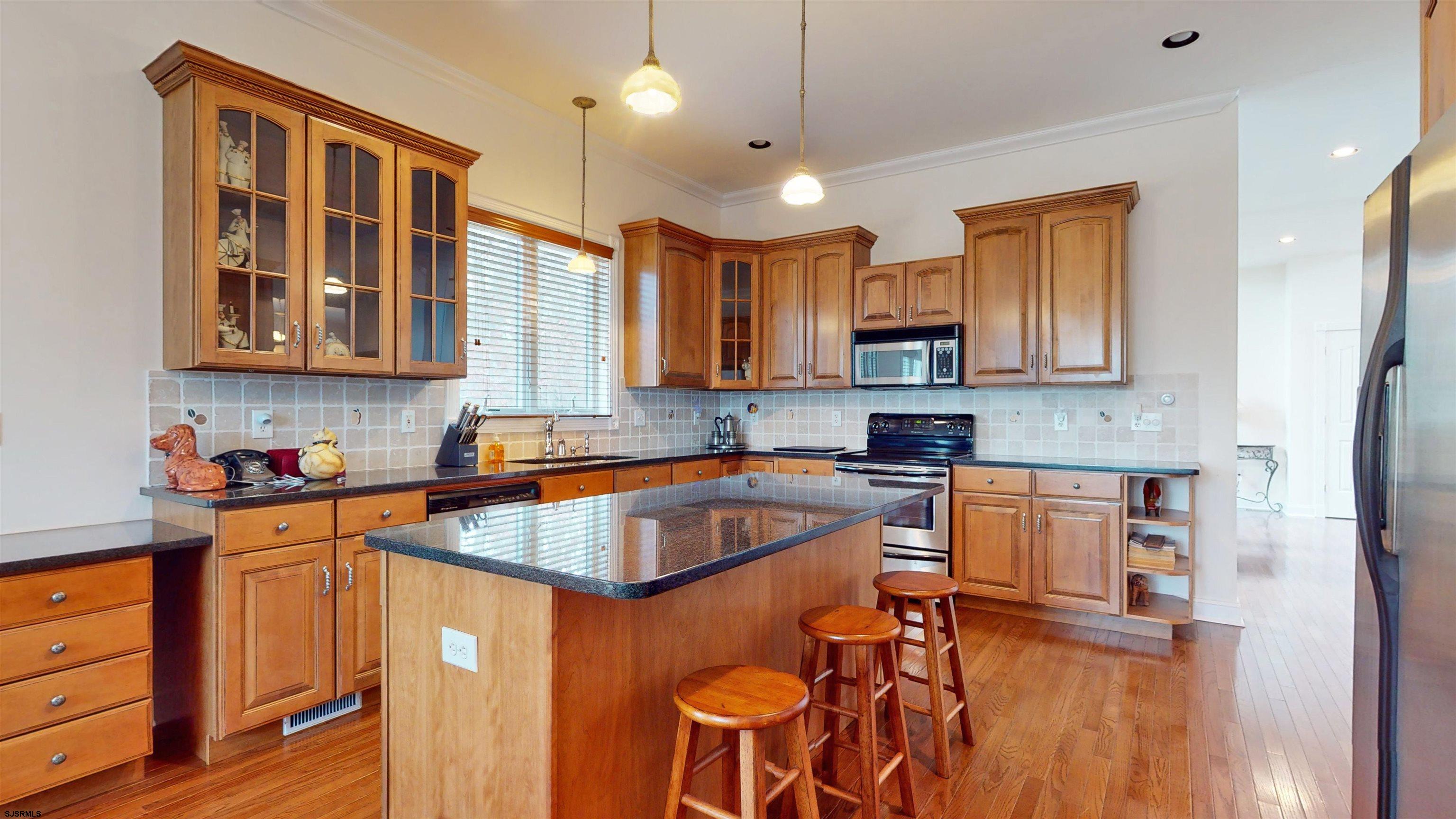 33 North New York Road Smithville, NJ 08205 - Photo 14 of 53 a kitchen with stainless steel appliances granite countertop a refrigerator a sink dishwasher a stove and white countertops with wooden floor