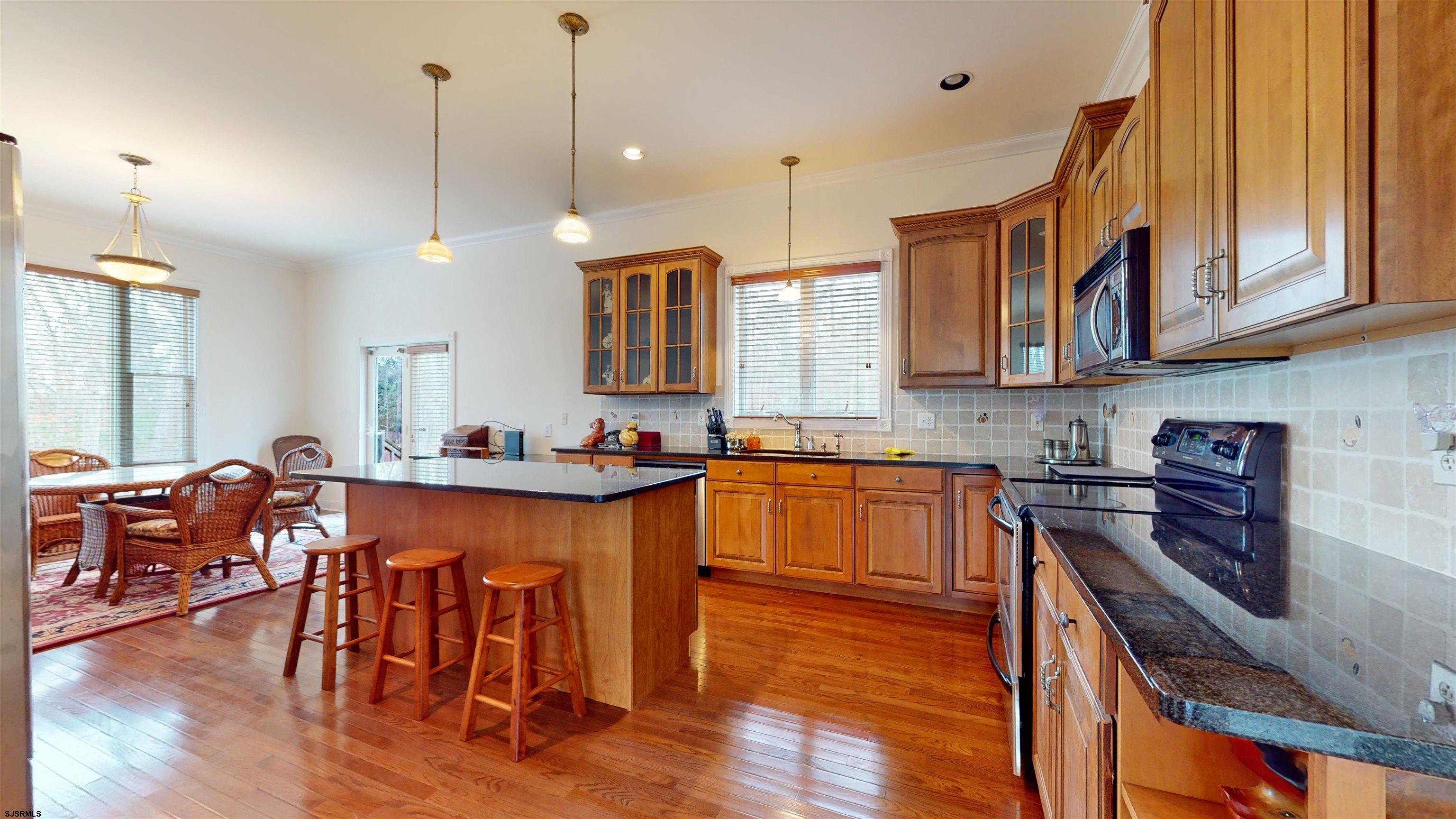 33 North New York Road Smithville, NJ 08205 - Photo 15 of 53 a kitchen with stainless steel appliances granite countertop wooden floors stove top oven and microwave