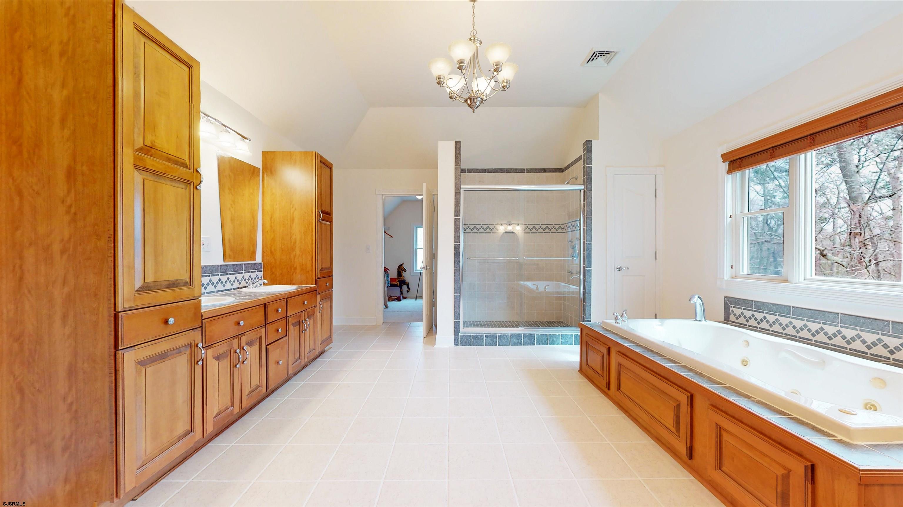 33 North New York Road Smithville, NJ 08205 - Photo 30 of 53 a spacious bathroom with a double vanity sink a large mirror and a bathtub