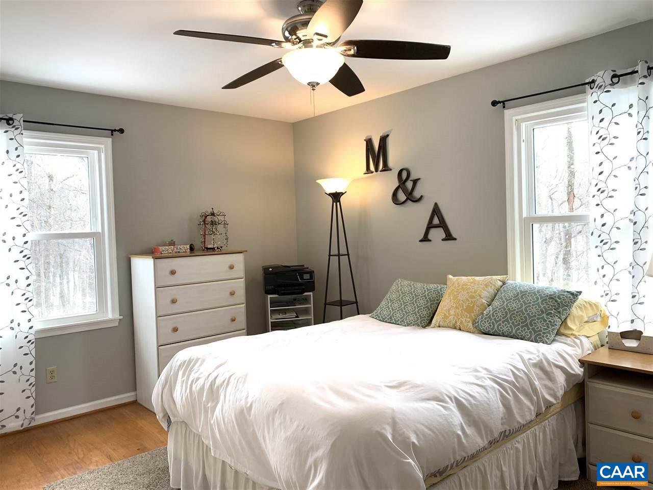 4354 Dickerson Road Charlottesville, VA 22911 - Photo 1 of 29 a bedroom with a large bed and a chandelier fan
