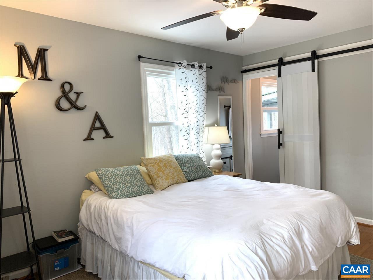 4354 Dickerson Road Charlottesville, VA 22911 - Photo 12 of 29 a bedroom with a large bed and a chandelier