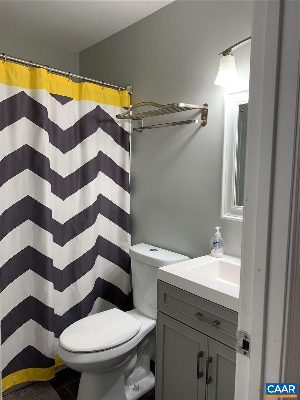 4354 Dickerson Road Charlottesville, VA 22911 - Photo 8 of 29 a bathroom with a sink a toilet a mirror and shower curtain