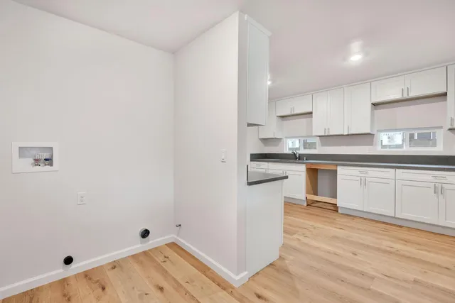 a kitchen with granite countertop white cabinets and white appliances