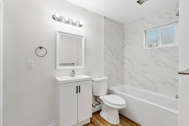 a bathroom with a sink a toilet and shower