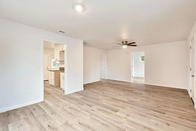 a view of empty room with wooden floor