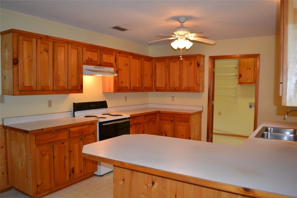 213 County Road 1997 Yantis, TX 75497 - Photo 16 of 39 a kitchen with a stove a sink dishwasher and a refrigerator
