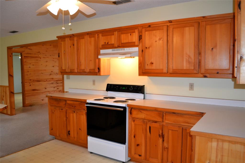 213 County Road 1997 Yantis, TX 75497 - Photo 17 of 39 a kitchen with stainless steel appliances granite countertop wooden cabinets a stove a sink and dishwasher