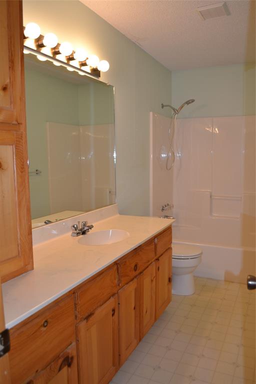 213 County Road 1997 Yantis, TX 75497 - Photo 32 of 39 a bathroom with a granite countertop sink a toilet and a shower