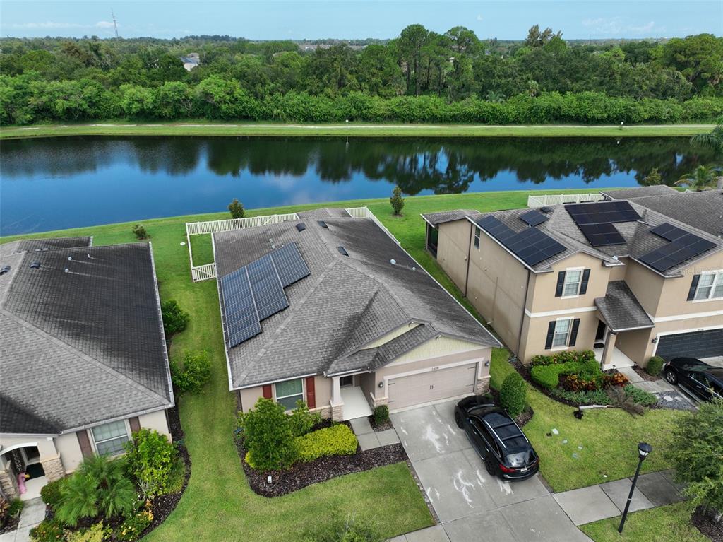 1606 Cabbage Key Drive Ruskin, FL 33570 - Photo 1 of 31 an aerial view of a house with a lake view and a large tree