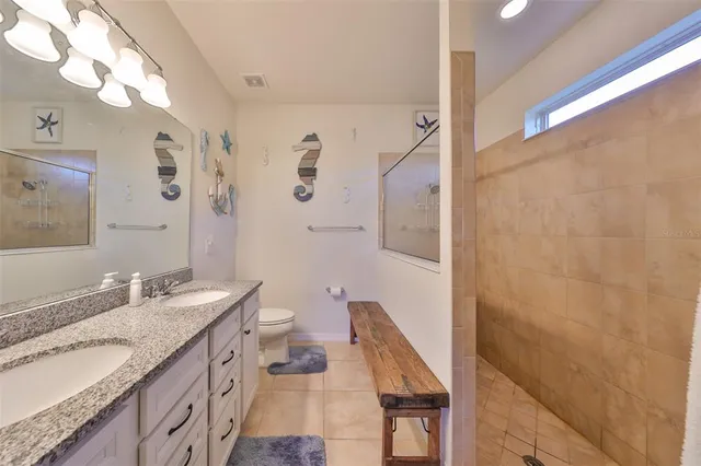 a bathroom with a granite countertop sink toilet and shower