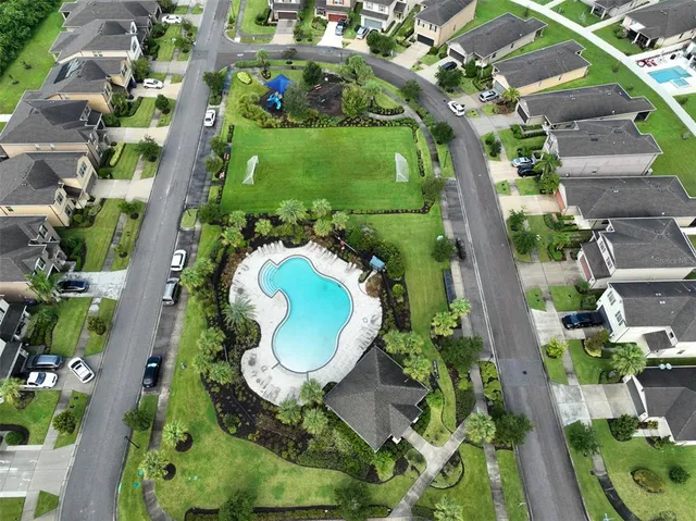an aerial view of a house with a yard and green space