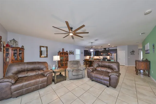a living room with furniture and a ceiling fan
