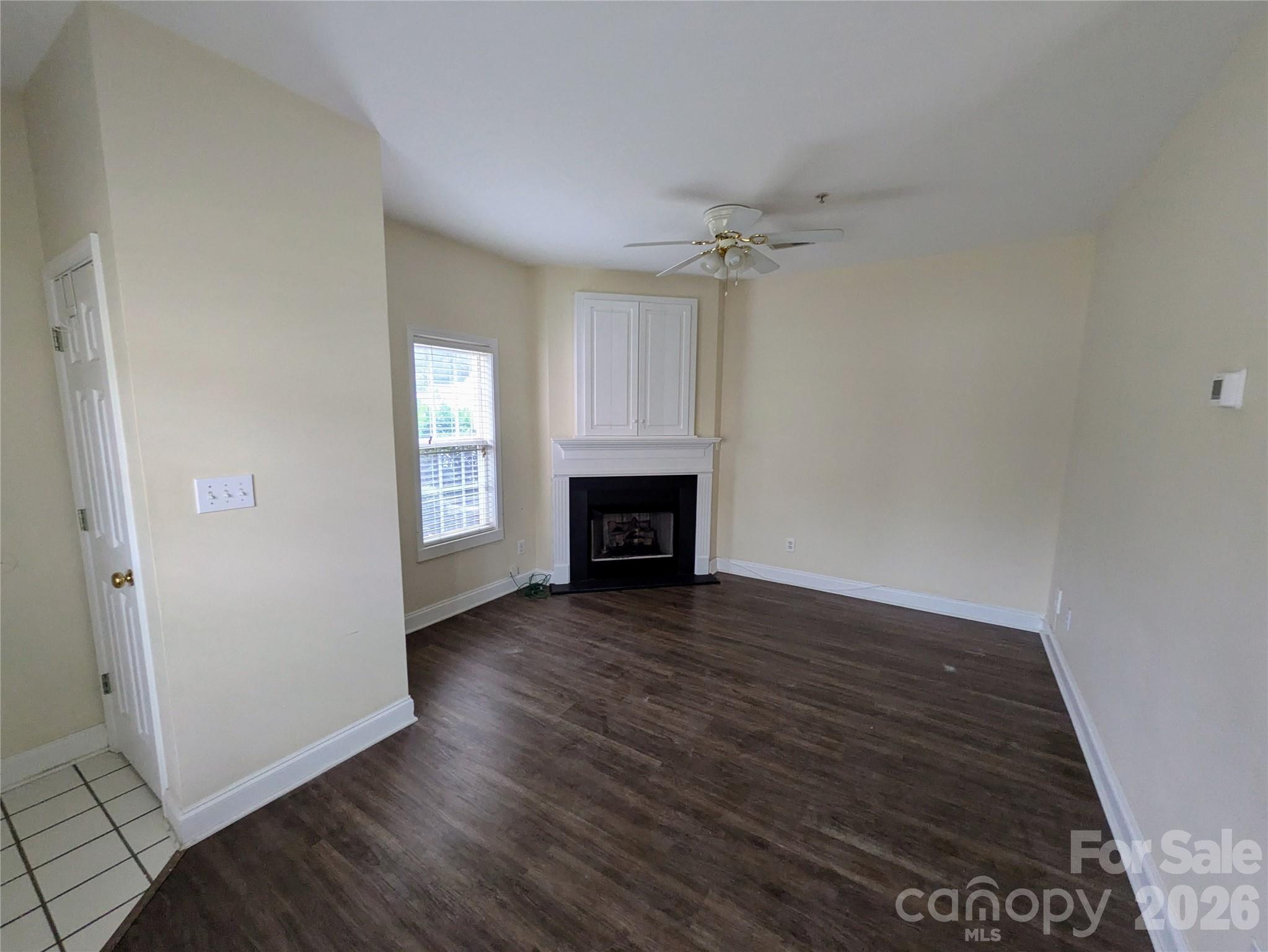 917 Shearer Street, Unit 20 Davidson, NC 28036 - Photo 5 of 16 an empty room with wooden floor fireplace and windows