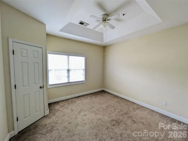 an empty room with a window and a fan