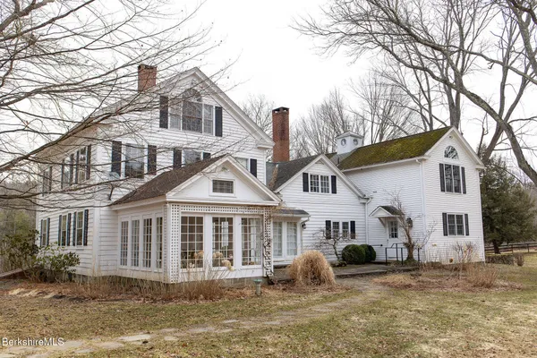 a front view of a house with a yard covered in snow
