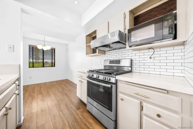 a kitchen with stainless steel appliances granite countertop a stove and a microwave