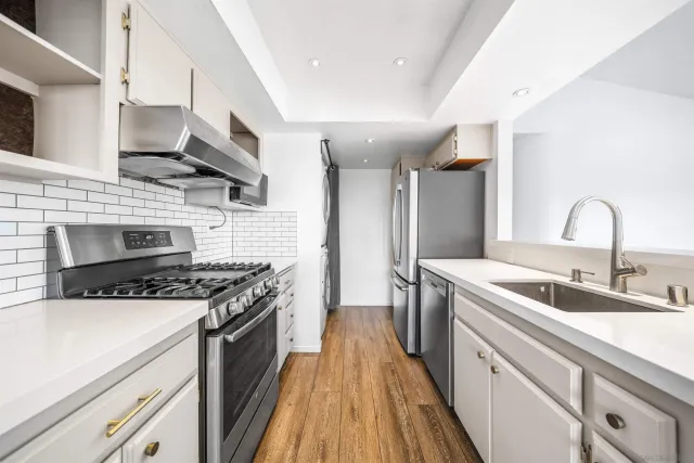 a kitchen with stainless steel appliances granite countertop a sink stove and cabinets