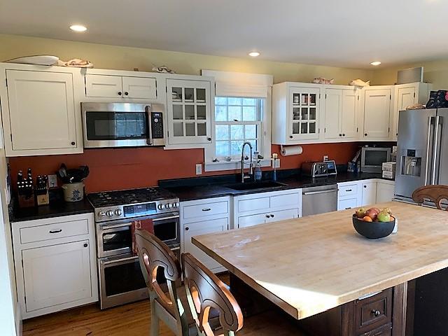 251 Tonset Road Orleans, MA 02653 - Photo 22 of 61 a kitchen with a stove a refrigerator and wooden cabinets