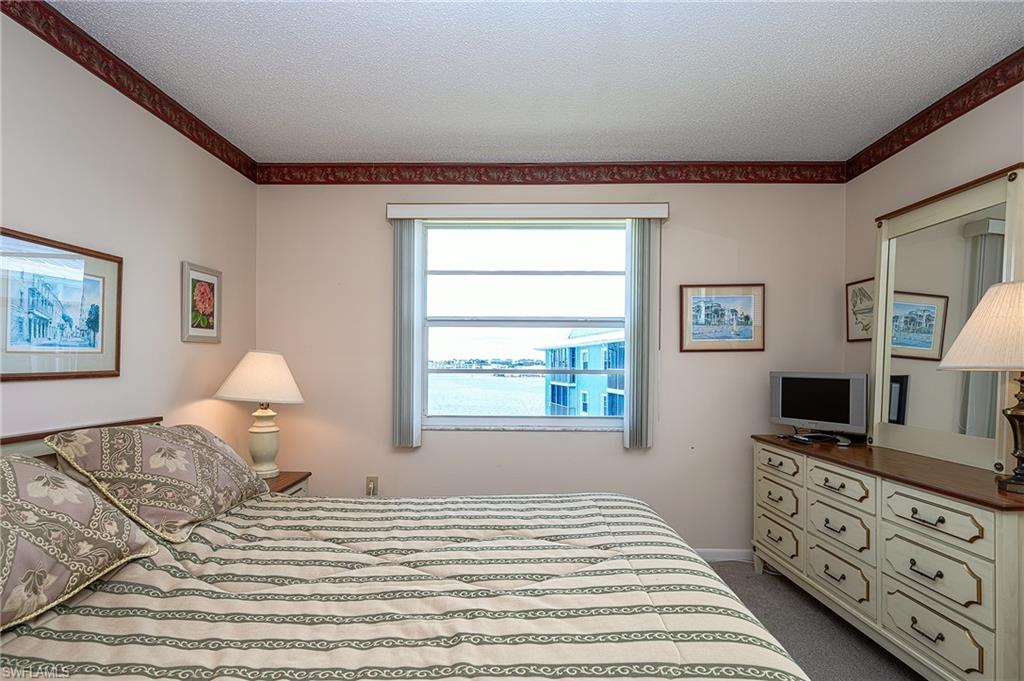 1280 Blue Point Avenue, Unit C30 Naples, FL 34102 - Photo 15 of 24 a bedroom with a bed and a flat screen tv