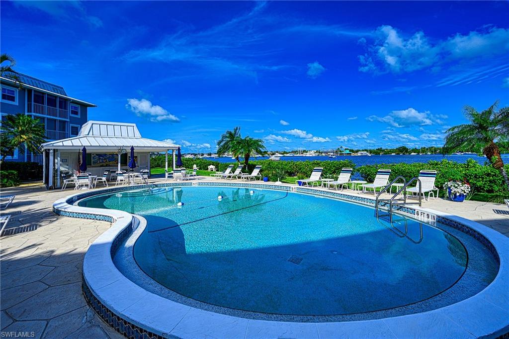 1280 Blue Point Avenue, Unit C30 Naples, FL 34102 - Photo 21 of 24 a view of a swimming pool with outdoor seating