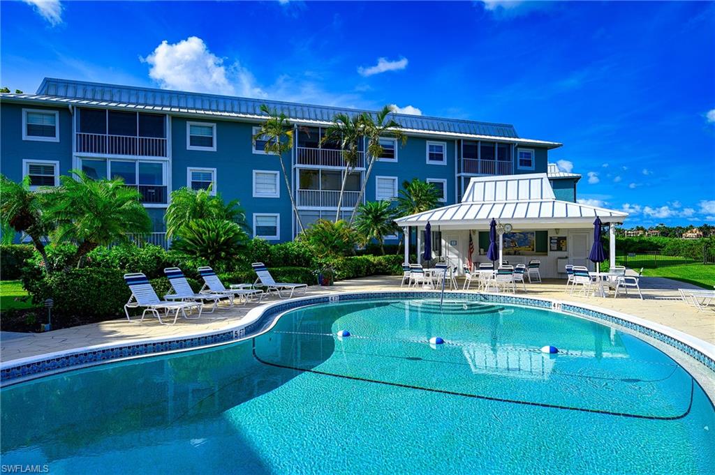 1280 Blue Point Avenue, Unit C30 Naples, FL 34102 - Photo 22 of 24 a front view of a house with swimming pool having outdoor seating