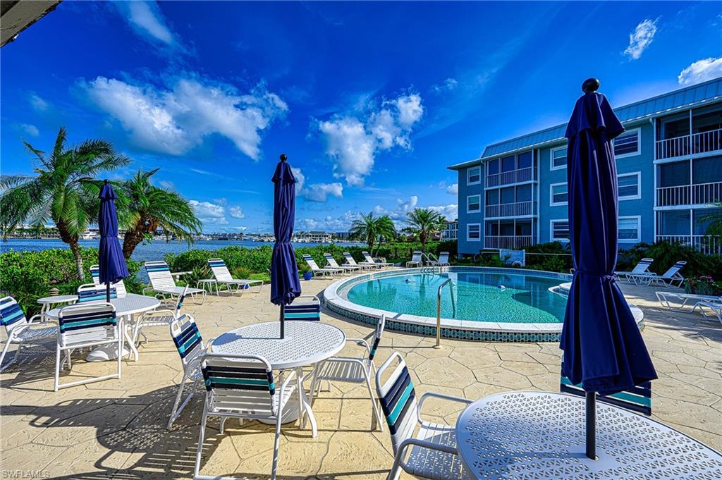 1280 Blue Point Avenue, Unit C30 Naples, FL 34102 - Photo 23 of 24 a view of a swimming pool with a patio and a yard