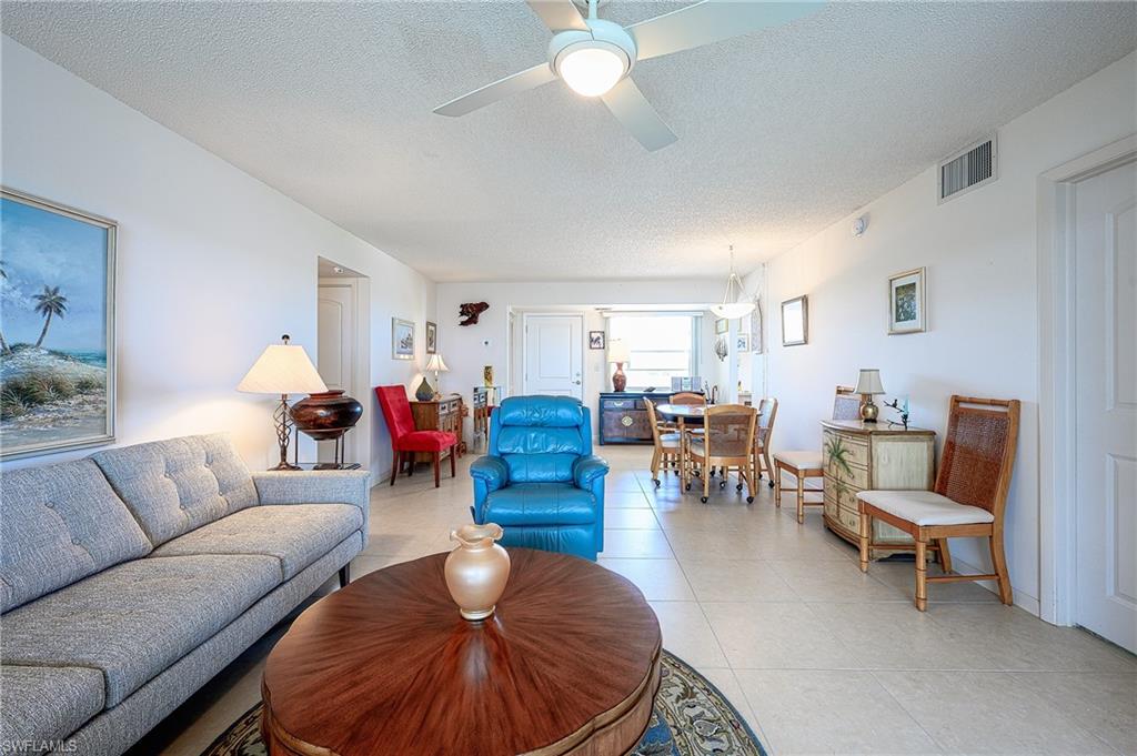 1280 Blue Point Avenue, Unit C30 Naples, FL 34102 - Photo 3 of 24 a living room with furniture and a chandelier
