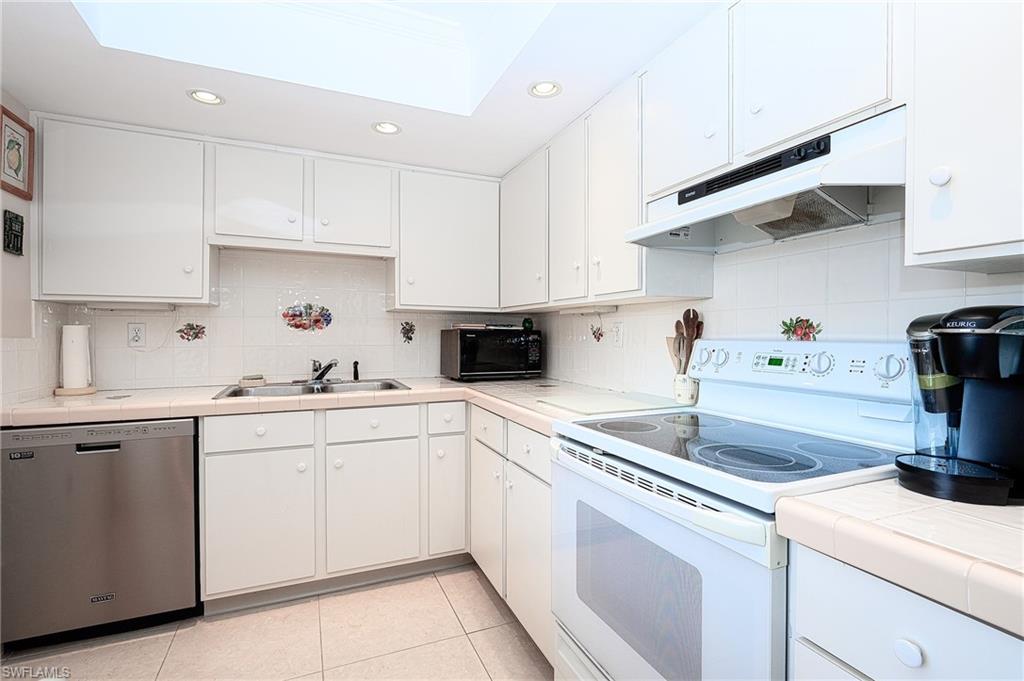 1280 Blue Point Avenue, Unit C30 Naples, FL 34102 - Photo 7 of 24 a kitchen with cabinets appliances a sink and a counter top
