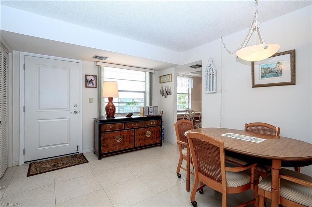 1280 Blue Point Avenue, Unit C30 Naples, FL 34102 - Photo 8 of 24 a room with a table chairs and a kitchen