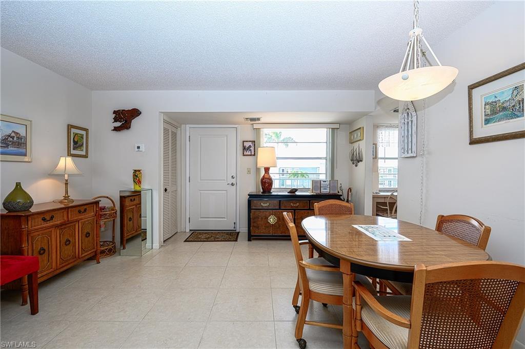 1280 Blue Point Avenue, Unit C30 Naples, FL 34102 - Photo 9 of 24 a view of a dining room with furniture and a chandelier