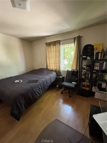 a bedroom with a bed gym equipment and a large window