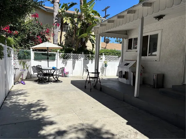 a view of a patio with table and chairs potted plants with wooden floor and fence