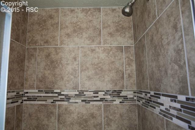 6965 Chippewa Road Colorado Springs, CO 80915 - Photo 11 of 31 Custom tile shower surround with glass tile inlay.