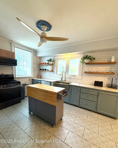 a large kitchen with stainless steel appliances granite countertop a sink and cabinets