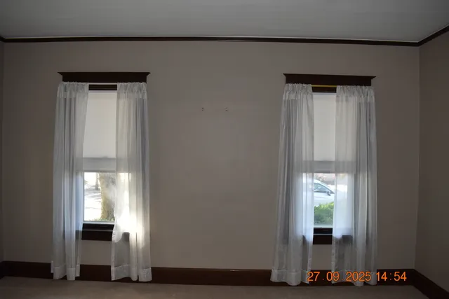 a view of a hallway with wooden floor and a living room