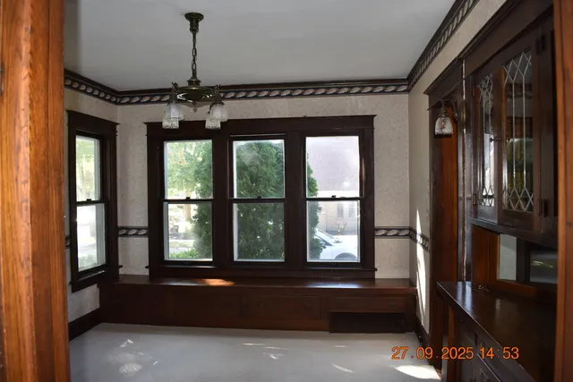 a living room with hardwood floor and large windows